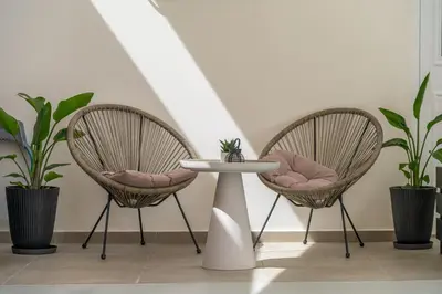 two chairs and a table in a room with plants at SugarDustApt Elegant Retreat 150m from the Sea in Chania Town