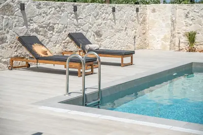 two lounge chairs next to a swimming pool at Murelos in Chania Town