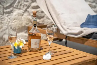 a bottle of wine and two glasses on a wooden table at Murelos in Chania Town