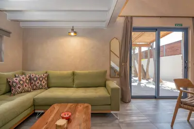 a living room with a green couch and a table at Murelos in Chania Town