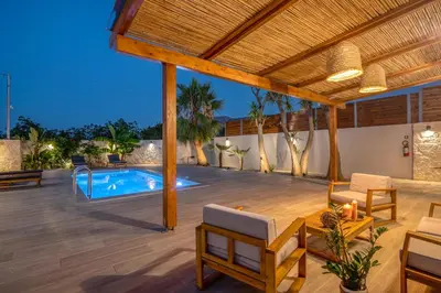 an outdoor patio with a swimming pool and a pergola at Murelos in Chania Town