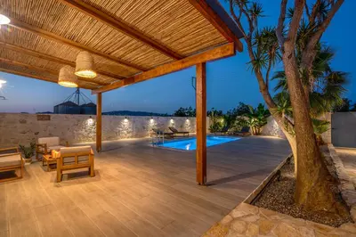 an outdoor deck with a pergola and a swimming pool at Murelos in Chania Town