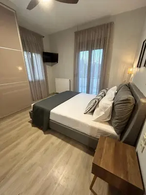 a bedroom with a large bed and a table at VENTO villa neriana in Khainderianá