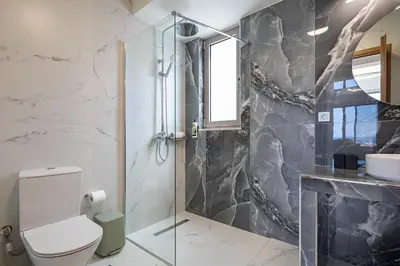 a bathroom with a toilet and a sink at Theo Luxury Villas With Sea View in Agia Marina Nea Kydonias