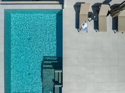an overhead view of a swimming pool with blue water at Theo Luxury Villas With Sea View in Agia Marina Nea Kydonias