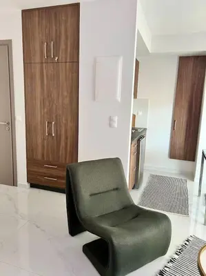 a green chair in a room with a kitchen at Hermes Studio - In the city just steps to the sea! in Chania Town