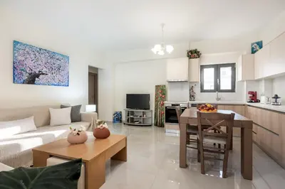 a kitchen and living room with a couch and a table at Newbulit Apartment 1km from the center of Chania in Chania Town