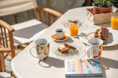 a table with a plate of food and cups of coffee at Lavande in Chania Town