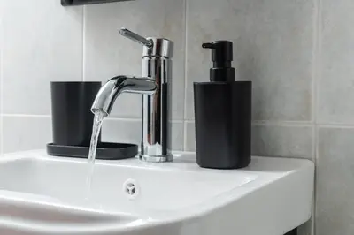 a sink with a faucet and two cups on it at Viola Apartment in Kissamos