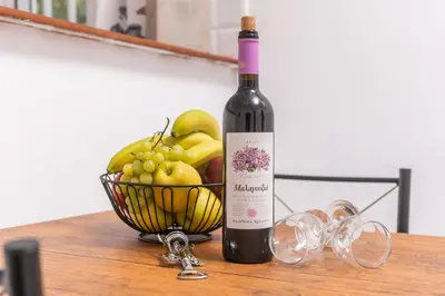 a bottle of wine next to a basket of fruit at Viola Apartment in Kissamos