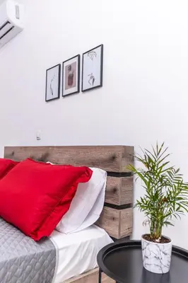 a bedroom with a red pillow and a table at Viola Apartment in Kissamos