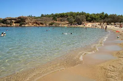 a group of people in the water at a beach at Ammos Family Villa in Daratso