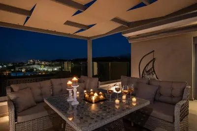 a living room with a table with candles on a balcony at Casa Platanias Bridge in Plataniás