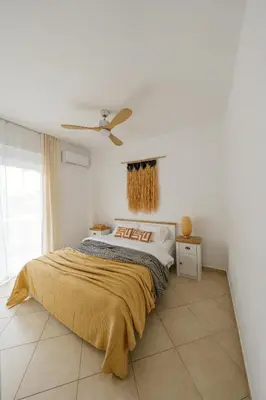 a bedroom with a bed and a ceiling fan at El Chacha Apartment in Galatás