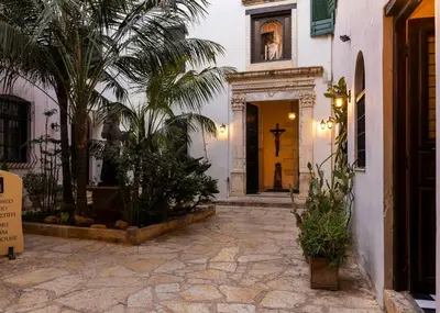 a courtyard with palm trees and a yellow door at Sundial Lodge in Chania Town