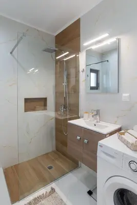 a bathroom with a shower and a sink and a washing machine at Casa Manou - Kalyves beach in Kalyves