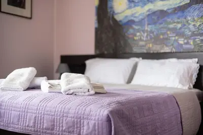 a bedroom with a purple bed with towels on it at Rastoni - Beach Family House in Chorafakia