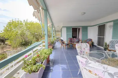a balcony with chairs and a table and some plants at Rastoni - Beach Family House in Chorafakia