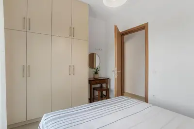 a bedroom with white cabinets and a bed and a mirror at Villa Terra Nuova in Kalyves