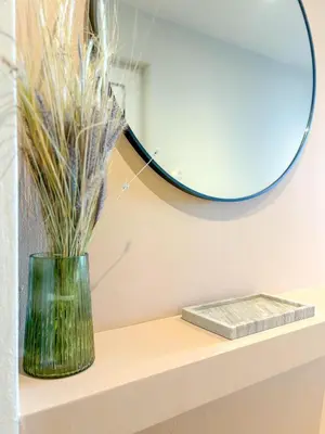a vase sitting on a shelf with a mirror at Vista Mare apartments in Palaiochóra