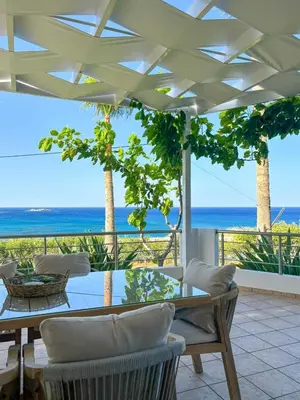 a dining room with a table and a view of the ocean at Vista Mare apartments in Palaiochóra