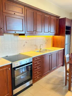 a kitchen with wooden cabinets and a sink and a stove at Vista Mare apartments in Palaiochóra