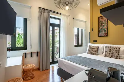 a bedroom with a bed and some windows at Amarillide rooms in Chania Town