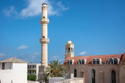 a mosque with two towers in front of a building at Casa Elysium - Chania Old City in Chania Town