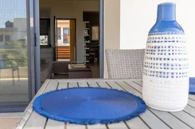 a blue plate sitting on a table with a vase at Maisonette with Exclusive Private Parking in Chania Town