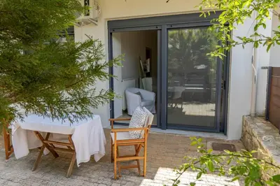 a patio with a table and chairs and sliding glass doors at Maisonette with Exclusive Private Parking in Chania Town