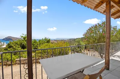 a white table on a balcony with a view of the ocean at Delta Sea View House in Plataniás