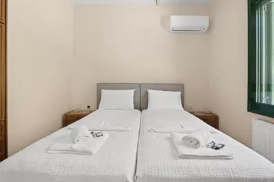 a large white bed with two towels on it at Delta Sea View House in Plataniás