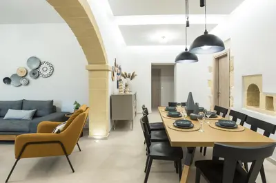 a dining room and living room with a table and chairs at Villa Savina in Plátanos