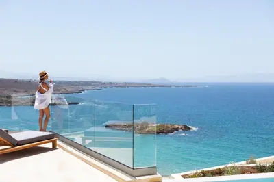 a woman standing on a balcony looking at the ocean at Casablanca Villa in Chania Town
