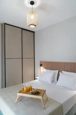 a bedroom with a bed with a tray of food on it at Dedalos City Apartment in Chania Town
