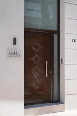 a brown door with a sign on the side of a building at Dedalos City Apartment in Chania Town