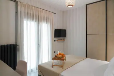 a bedroom with a bed and a table with a tv at Dedalos City Apartment in Chania Town