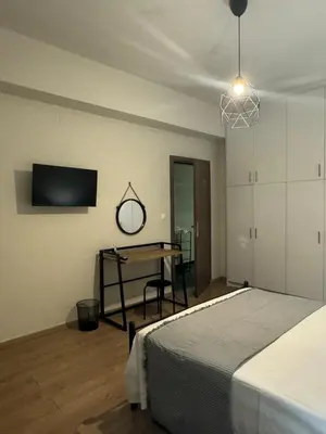 a bedroom with a bed and a desk and a tv at Catherine Apartment in Chania Town