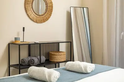 a bedroom with a bed with two pillows and a mirror at Jo's Central & Cozy Apartment in Chania Town