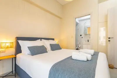 a bedroom with a large white bed with towels on it at Jo's Central & Cozy Apartment in Chania Town