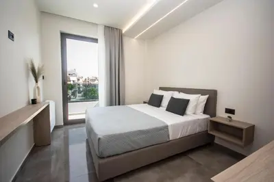 a bedroom with a bed and a large window at Celestial Apartments in Chania Town