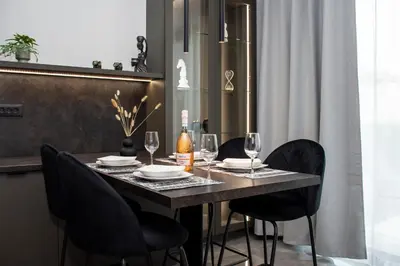 a dining room table with black chairs and wine glasses at Celestial Apartments in Chania Town