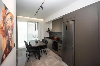 a kitchen with a table and a stainless steel refrigerator at Celestial Apartments in Chania Town