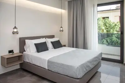 a bedroom with a bed and a large window at Celestial Apartments in Chania Town