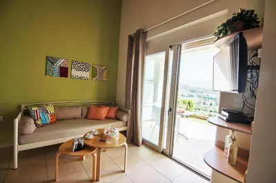 a living room with a couch and a sliding glass door at Aksos Suites Accessible Accommodation in Ayiá