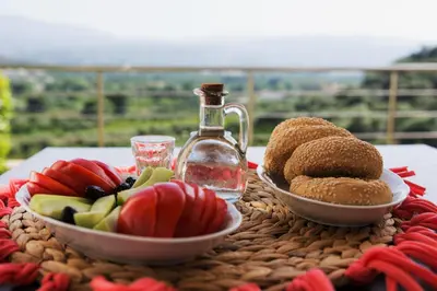 a table with plates of food and a bottle of water at Aksos Suites Accessible Accommodation in Ayiá