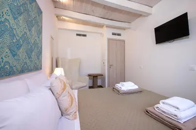 a living room with a white couch and a tv at Casa Dione - Chania Old Town in Chania Town
