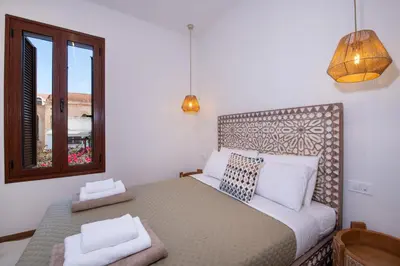 a bedroom with a bed with two pillows and a window at Casa Dione - Chania Old Town in Chania Town