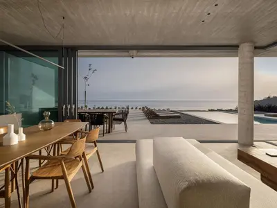 a dining room with a view of the beach at Alba Cave Villas in Chania Town