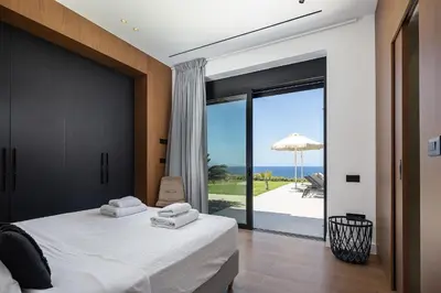 a bedroom with a bed and a view of the ocean at Kiyomi Villa in Chania Town